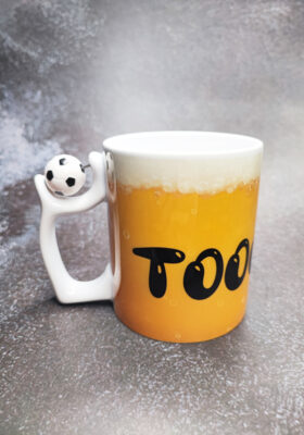 Du liebst Fußball und feierst bei jedem Tor? Dann ist diese Tasse mit Spruch genau das Richtige für dich! Die Tasse von Super-Mug ist mit dem freudigen Schrei: "TOOOOOOOOOOOR!" versehen und einem Biermotiv im Hintergrund. Außerdem hat sie einen drehbaren Fußball am Henkel