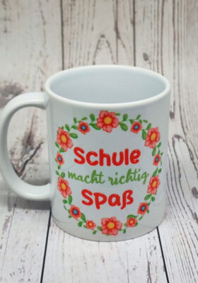 ein Blumenkranz mit dem Spruch. Der Becher sieht einfach zum Liebhaben aus.  Er ist aus weißem Porzellan