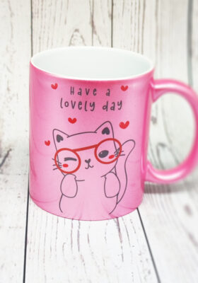 Du bist auf der Suche nach einem glitzernden Geschenk für die beste Freundin oder dich selbst? Dann haben wir genau das Richtige für dich: einen Kababecher mit dem Spruch “have a lovely day” und einer Katze mit Brille von Super-Mug. Diese Katze ist vorne und hinten auf dem Becher bedruckt und sieht einfach zum Schnurren aus. Sie hat eine Brille und Herzen um sich herum und strahlt Liebe und Glück aus. Der Becher ist aus Keramik